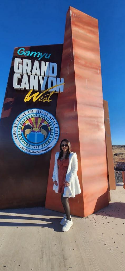 Traveller beside the Grand Canyon West and Hualapai Nation entrance marker