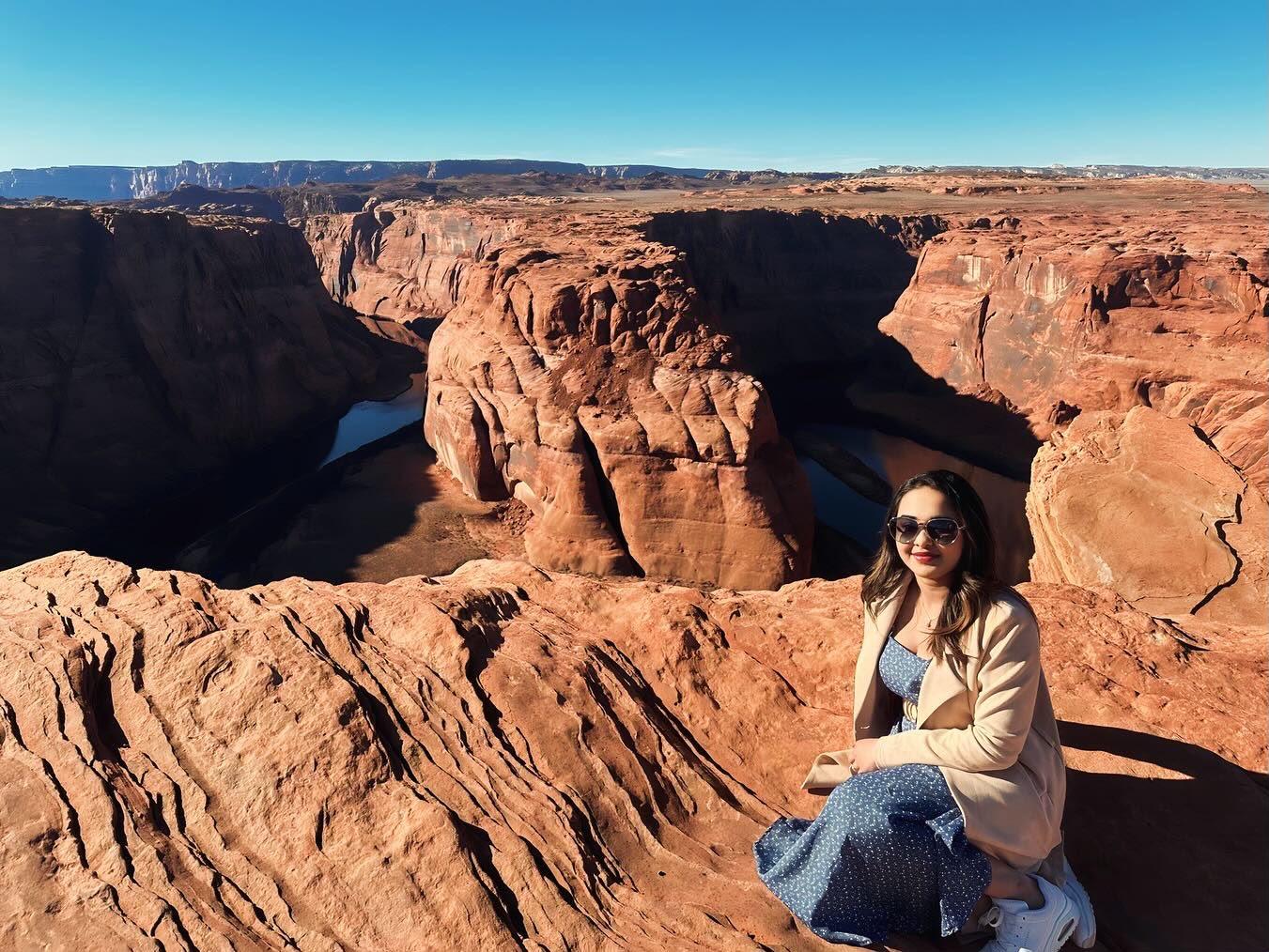 Traveller seated above the Colorado River curve at Horseshoe Bend