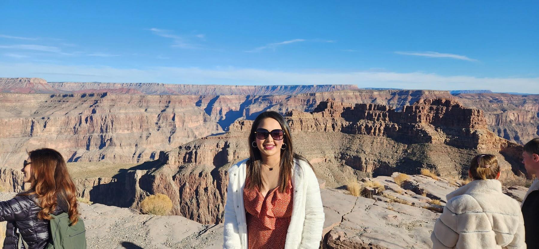 Traveller standing before the layered canyon walls at Grand Canyon West