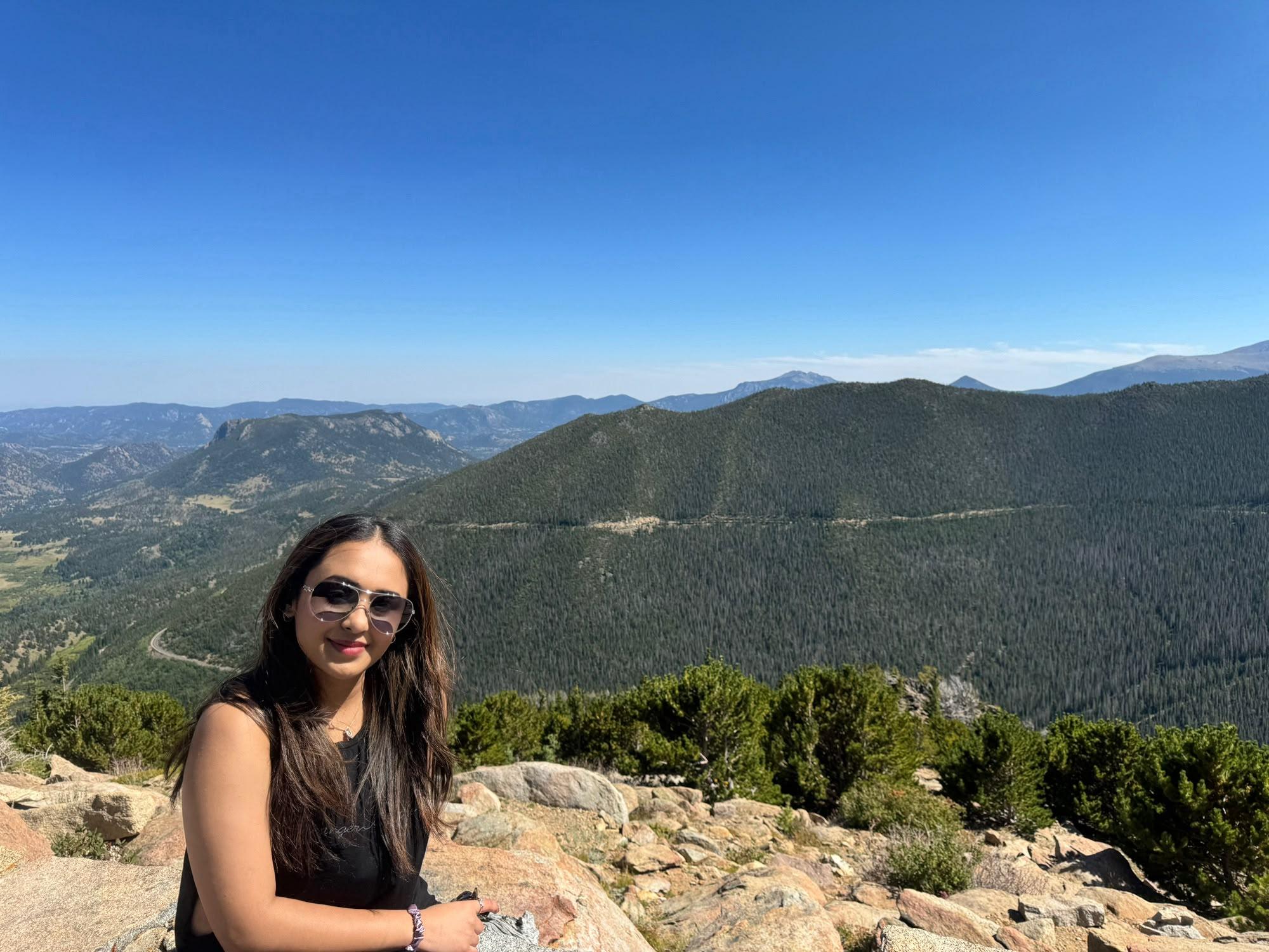 Traveller seated at a panoramic overlook above Estes Park