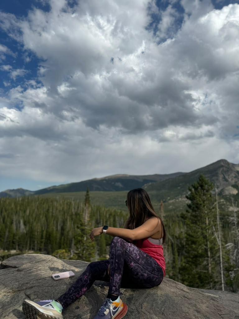 Traveller looking toward mountains beneath dramatic storm clouds