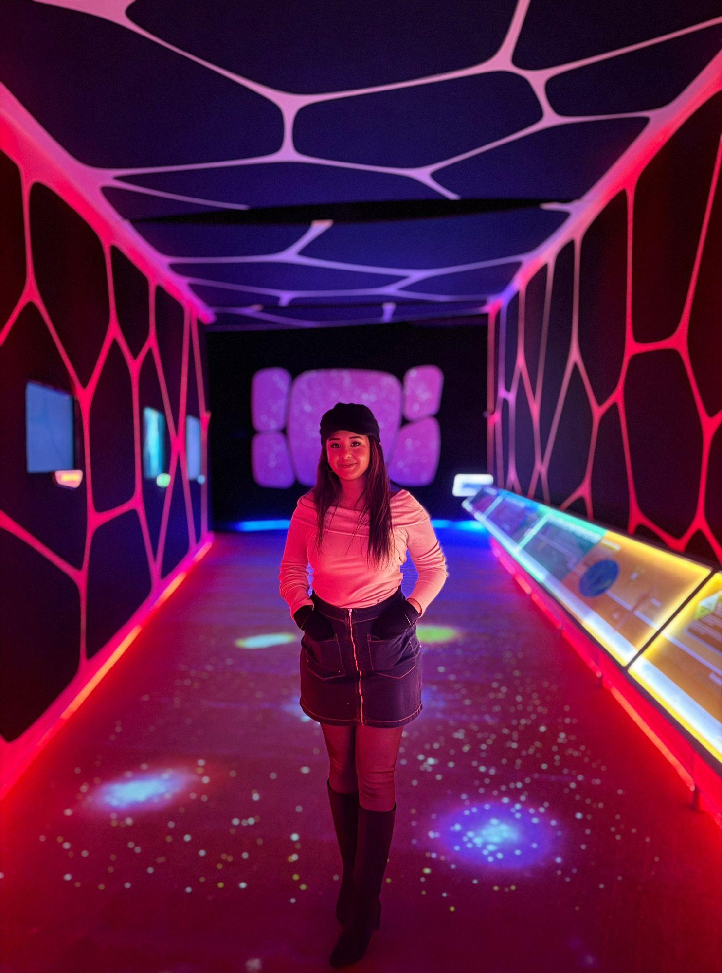 Traveller inside a neon-lit interactive astronomy gallery
