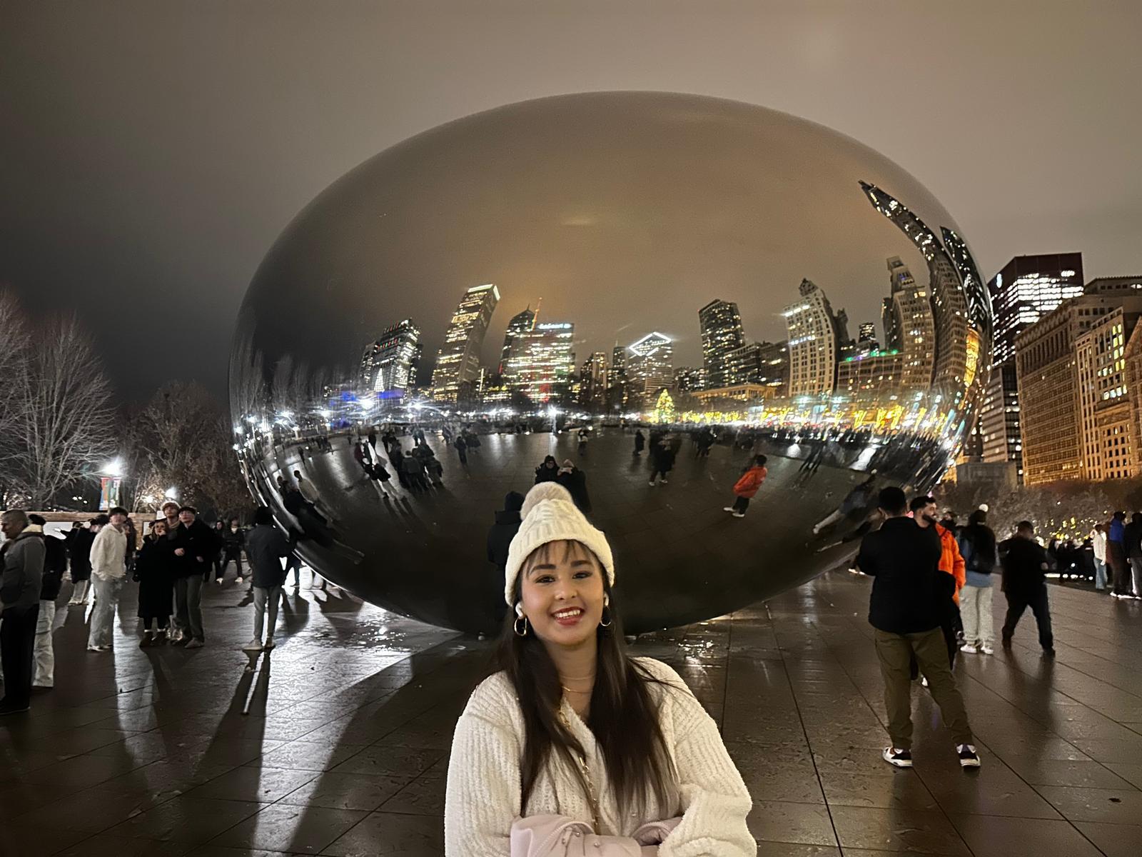 Traveller in front of Cloud Gate at night in Millennium Park
