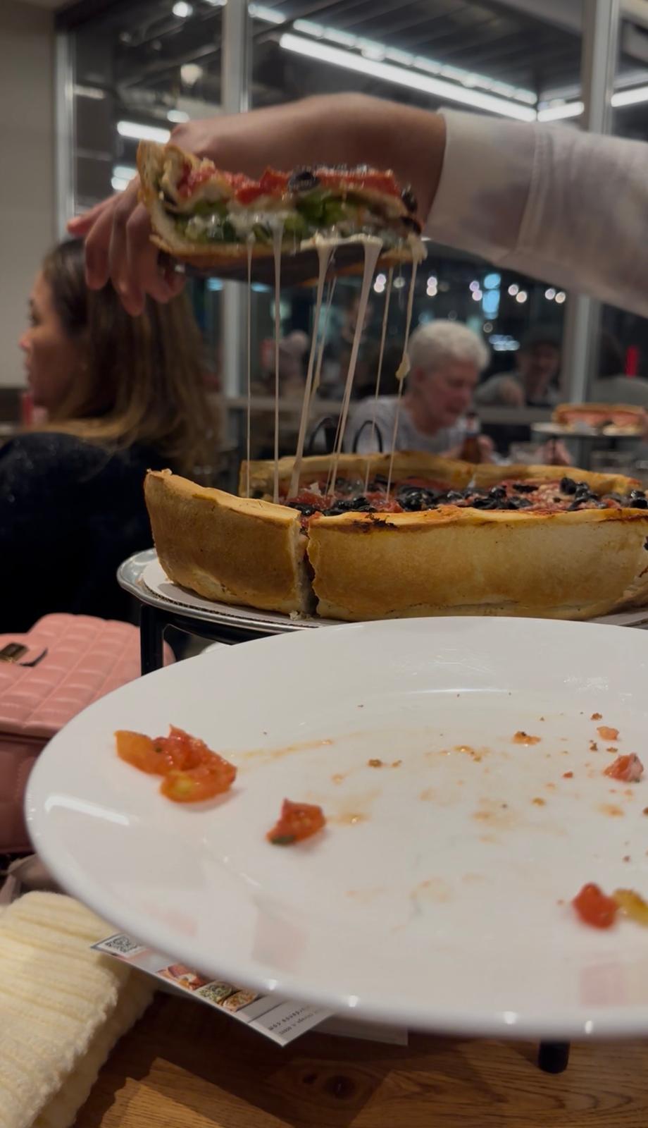 Deep-dish pizza with a cheese pull during a Chicago meal