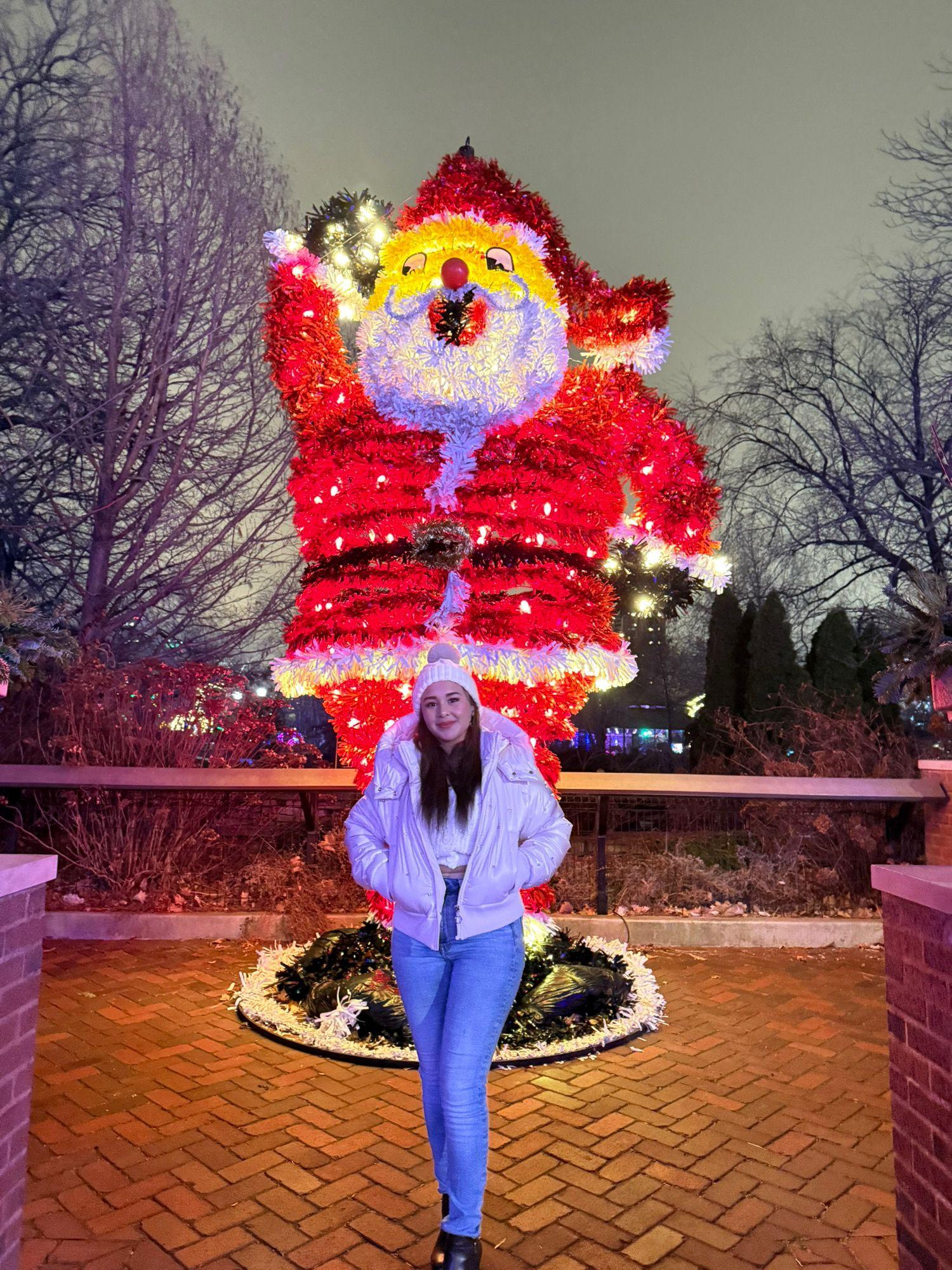 Traveller standing in front of a large illuminated Santa display