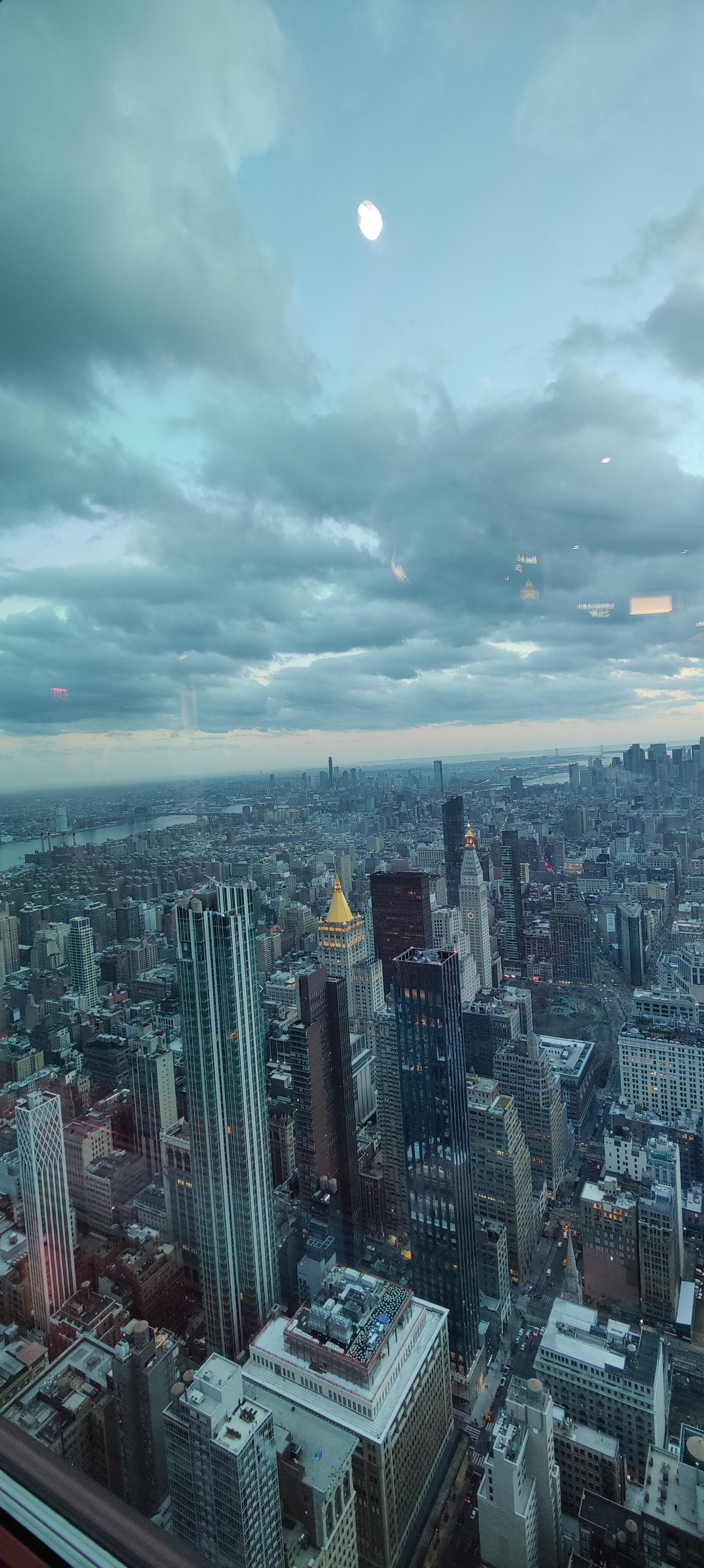 Manhattan skyline beneath dramatic clouds from an observation deck