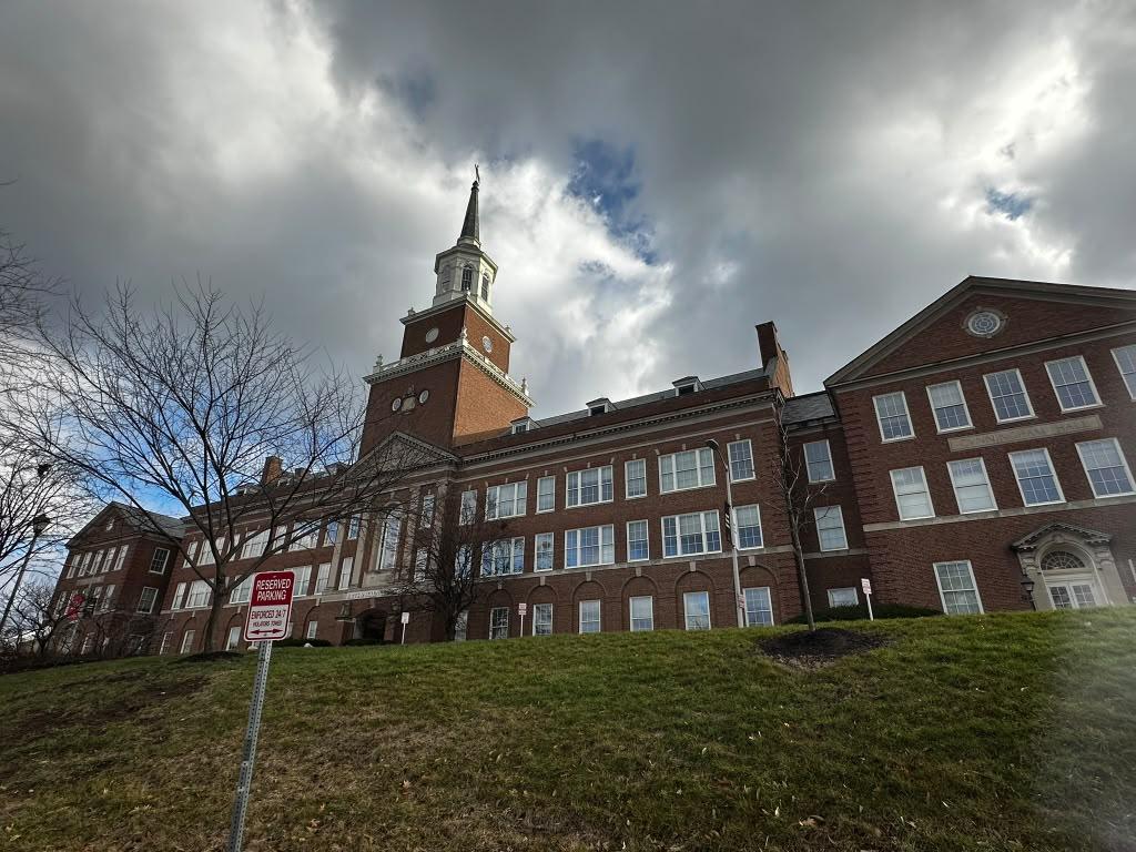 Historic University of Cincinnati building beneath dramatic clouds