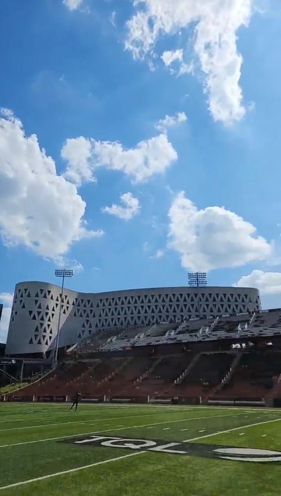 Nippert Stadium seating and field beneath dramatic summer clouds
