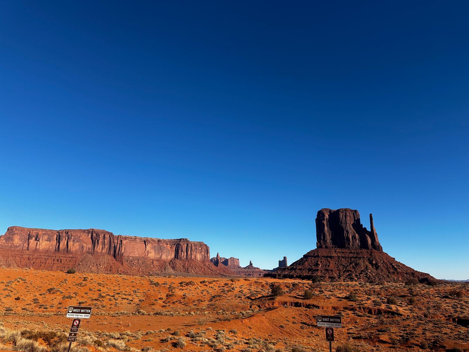 Monument Valley road and directional signs surrounded by red desert