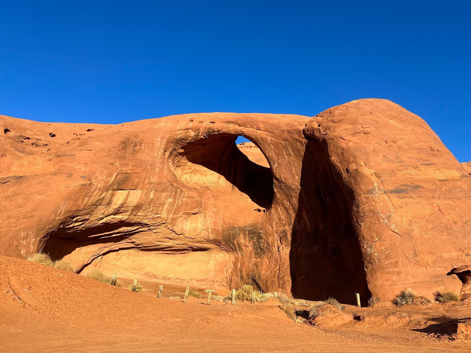Large sunlit sandstone arch in Monument Valley