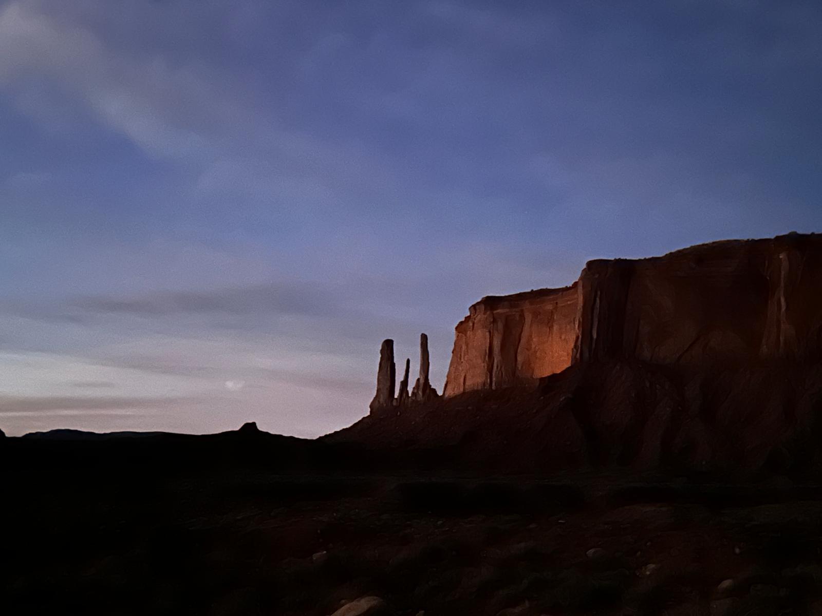 Monument Valley mesa and spire silhouetted beneath a pastel twilight sky
