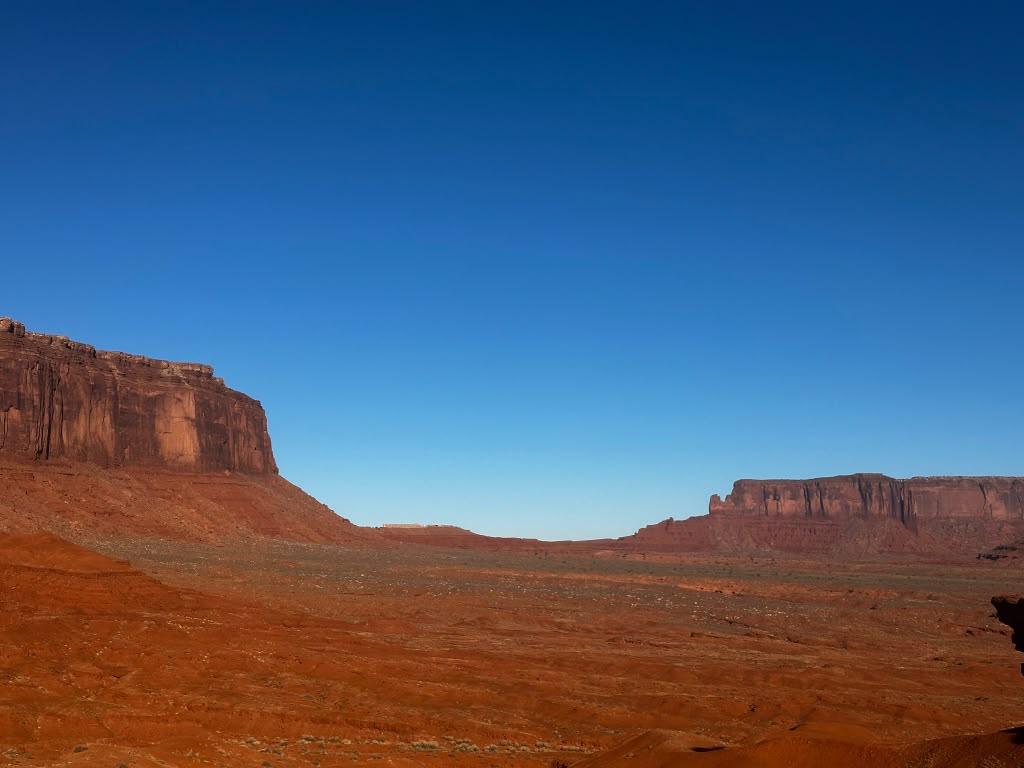 Wide red-earth panorama across Monument Valley
