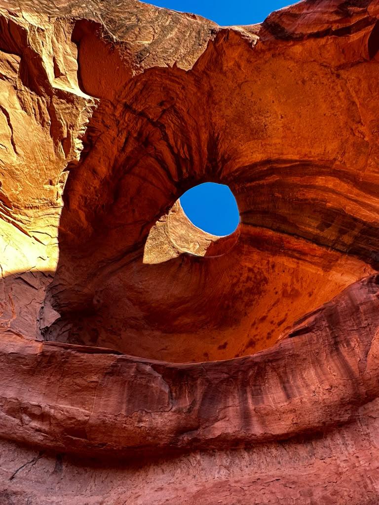 Circular natural window inside layered red sandstone