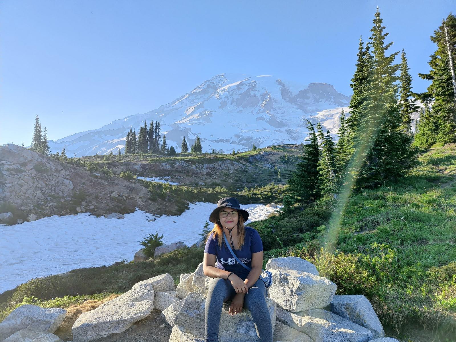 Traveller seated on rocks with Mount Rainier behind