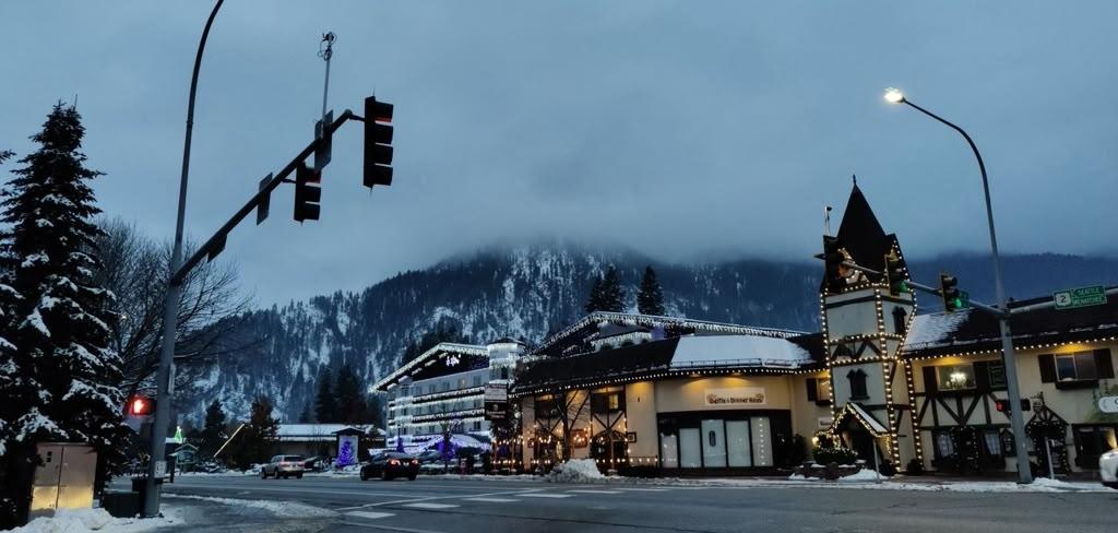 Snowy Bavarian-style street in Leavenworth beneath misty mountains