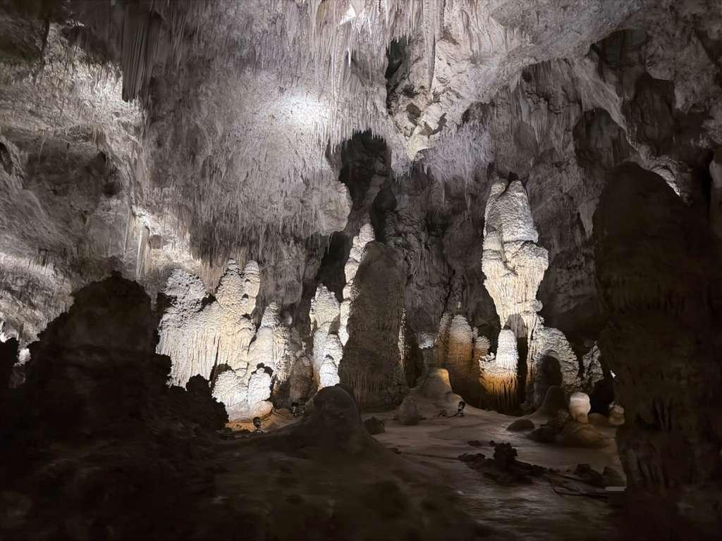 Illuminated stalagmites rising across the cavern floor