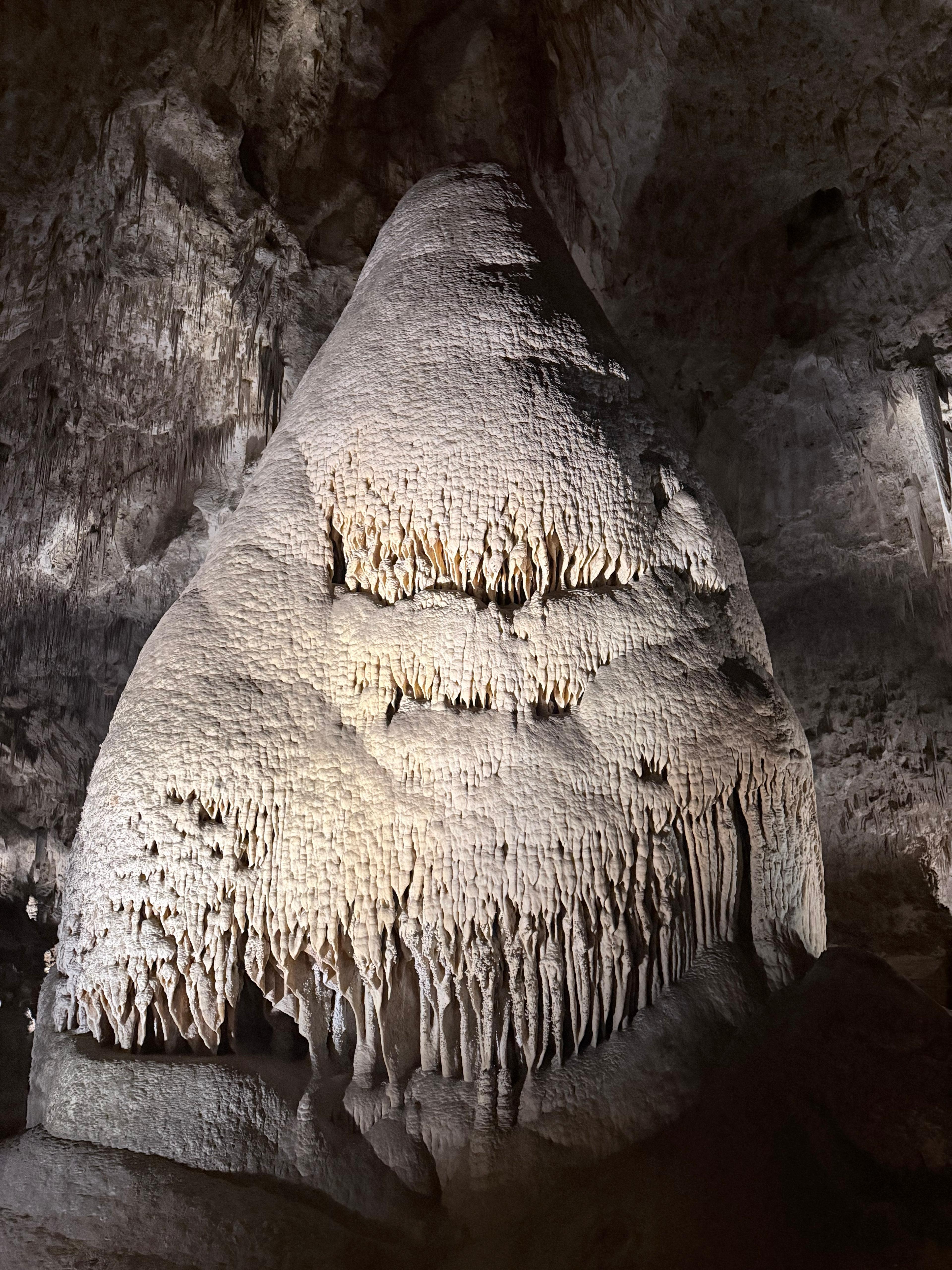 Tall cone-shaped cave formation covered in delicate mineral layers